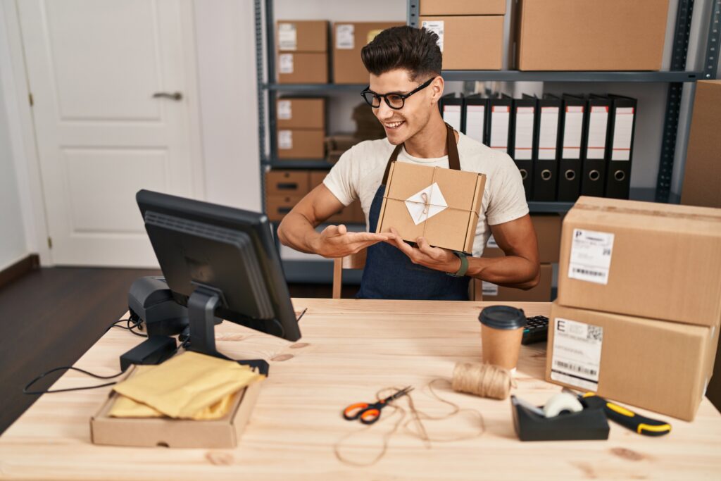 young hispanic man ecommerce business worker having video call showing package office